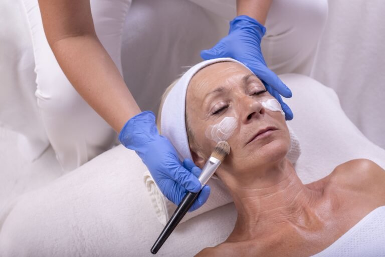 Closeup of a Caucasian senior woman applying face cream in a beauty salon